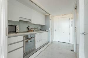 uma cozinha com armários brancos e um micro-ondas em Duplex LOFT Apartamento con Parking GRATIS em Valência