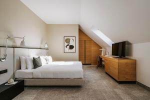 a bedroom with a bed and a desk and a television at Poziom 511 Jura Wellness Hotel & Spa in Ogrodzieniec