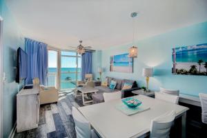 a living room with a table and a living room with the ocean at Prince Resort Oceanfront 1834 at Cherry Grove Pier in Myrtle Beach