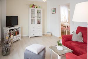 ein Wohnzimmer mit einem roten Sofa und einem TV in der Unterkunft Apartments Am Kupferberg in Walkenried
