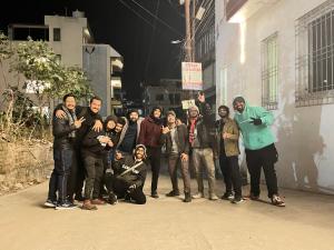 Un groupe de personnes debout à côté d'un bâtiment dans l'établissement Joey's Hostel Rishikesh, à Rishikesh