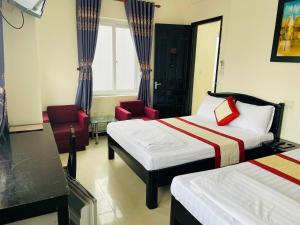 a hotel room with two beds and a chair at Canary Hotel Hue in Hue