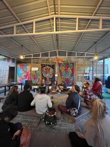 a group of people sitting on the floor in a room at Joey's Hostel Rishikesh in Rishīkesh