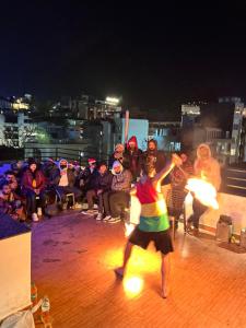 a group of people watching a woman dancing at night at Joey's Hostel Rishikesh in Rishīkesh