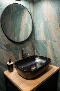 a bathroom with a black sink and a mirror at Pokoje gościnne AuRoom in Złoty Stok