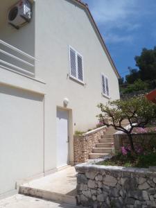 ein weißes Haus mit einer weißen Tür und einer Treppe in der Unterkunft Sunny P in Primošten