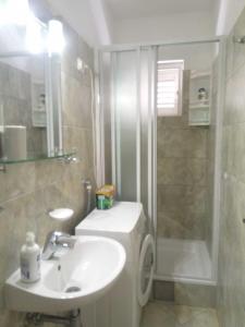 uma casa de banho com um lavatório e um chuveiro em Sunny P em Primošten