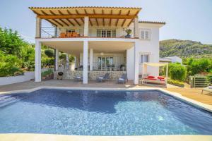 a villa with a swimming pool in front of a house at Villa Heura 18 in Alcudia