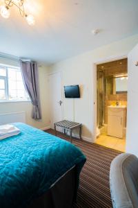 a bedroom with a blue bed and a bathroom at White Lion Hotel in Crewe