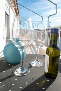 two wine glasses and a bottle on a table at KALLIÁNI HOUSE vila kiki in Flogita