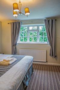 a bedroom with a bed and a large window at White Lion Hotel in Crewe