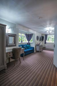 a living room with a blue couch and a table at White Lion Hotel in Crewe