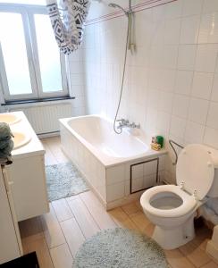 a bathroom with a tub and a toilet and a sink at Superbe appartement au coeur du quartier européen in Brussels