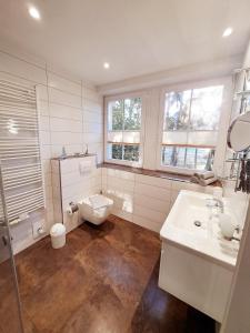 a white bathroom with a toilet and a sink at Zur Alten Post Prora in Binz