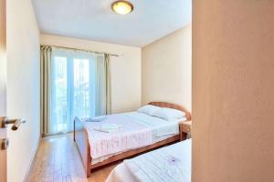 ein Schlafzimmer mit einem Bett und einem großen Fenster in der Unterkunft Apartments LUX Milano, Savina,Herceg-Novi in Herceg-Novi