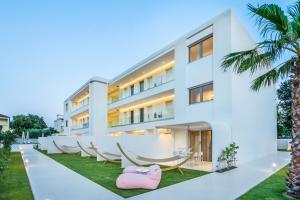 an exterior view of a building with hammocks and palm trees at Cocoοns Luxury Suites & Villas in Fourka