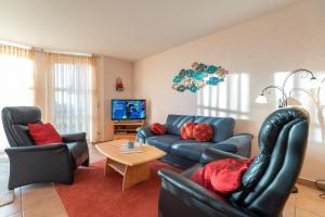 GummlinにあるFerienwohnung Gothensee Gummlinのソファと椅子とテレビのあるリビングルーム