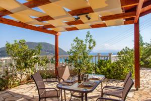 een patio met een tafel en stoelen en uitzicht bij Dream Villa with Seaviews in Vasiliki