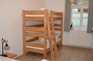 Ce lit superposé en bois se trouve dans un dortoir doté d'une fenêtre. dans l'établissement Apartmán Hubertus – Karlova Studánka, à Karlova Studánka