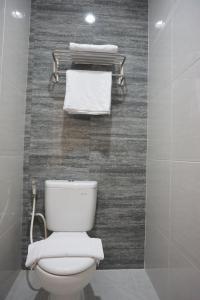 a white toilet in a bathroom with towels at Aurora House Surabaya in Wijung