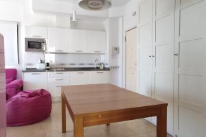 uma cozinha com uma mesa de madeira e uma cadeira roxa em Espectacular Ático con excelentes vistas. em Almeria