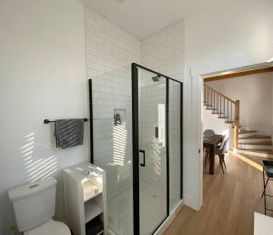a bathroom with a toilet and a staircase at The Millhouse Oceanfront Cottage 