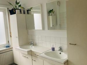 Baño blanco con 2 lavabos y espejo en Ruime woning met 4 slaapkamers nabij Antwerpen en haven, en Brasschaat