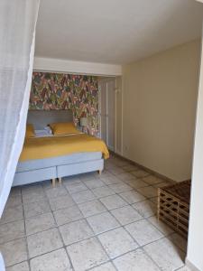 ein Schlafzimmer mit einem Bett und Fliesenboden in der Unterkunft Villa Thebaïde Chambres d'hôtes in Laudun