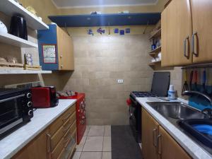 a small kitchen with a sink and a stove at Pozzuoli 100per100 Home in Pozzuoli