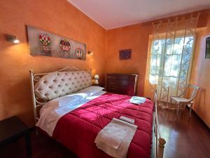 een slaapkamer met een groot bed en een rode deken bij L'antico Granaio in Paliano