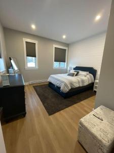 a bedroom with a bed and a desk and windows at The Millhouse Oceanfront Cottage 