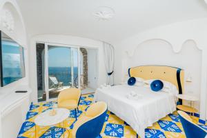 a room with a bed with chairs and a table at Hotel Cetus in Cetara
