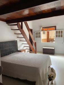 Un dormitorio con una cama blanca y una escalera en Casa de Praia - Interlagos, en Camaçari