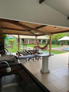 cocina con patio con sillas y hamaca en Casa de Praia - Interlagos, en Camaçari