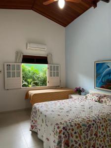 1 dormitorio con 2 camas y ventana en Casa de Praia - Interlagos, en Camaçari