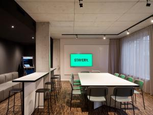 a conference room with a green screen on a wall at STAYERY Bremen in Bremen