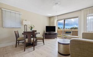 a living room with a table and a television at Plantation Hale Suites in Kapaa
