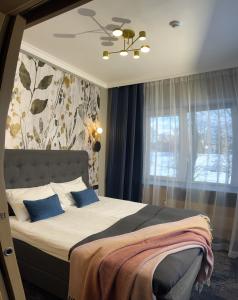 - une chambre avec un lit doté d'oreillers bleus et d'une fenêtre dans l'établissement Sadama street Villa, à Pärnu