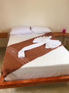 duas camas com lençóis brancos e toalhas em Recanto de Maragogi em Maragogi