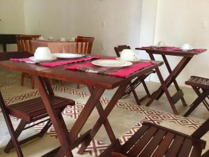 una mesa de madera con platos y platos. en Recanto de Maragogi, en Maragogi