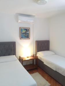 ein Zimmer mit 2 Betten und einem Tisch dazwischen in der Unterkunft Sunny P in Primošten