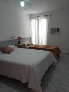 una camera d'albergo con due letti e una finestra di DEPARTAMENTO Alicia 1 a Santiago del Estero