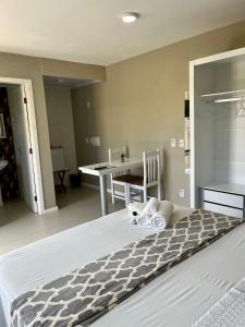 1 dormitorio con 1 cama con mesa y sillas en Pousada Mercosul, en Alegrete