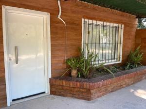 una puerta a una casa con plantas al lado en La Quinta Departamento en Santa Rosa