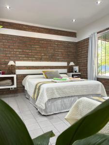 a bedroom with two beds and a brick wall at La Quinta Departamento in Santa Rosa