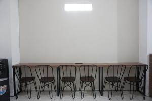 une table avec quatre chaises dans une pièce dans l'établissement Aurora House Surabaya, à Wijung
