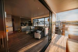 a living room with a couch and a kitchen at Schwimmendes Haus - Hausboot Trinity in Peenemünde