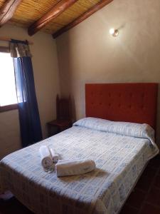 a bedroom with a bed with two towels on it at Hotel La Herencia in Tilcara