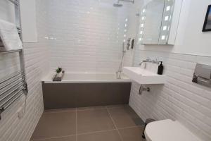 a bathroom with a tub and a sink and a toilet at Modern Apartment for Contractors & Small Groups by Stones Throw Apartments - Free Parking - Sea View in Worthing
