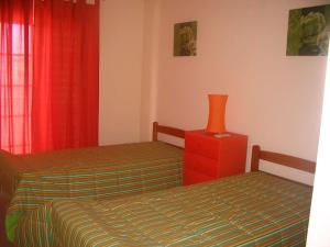- une chambre avec 2 lits et un vase sur une commode dans l'établissement Sol e Mar, à Vila Nova De Cacela 5 autres photos